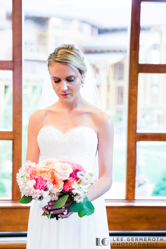 Bride looking at flowers - Stowe Mountain Resort Wedding by Lee Germeroth Photography